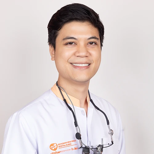 Portrait of a male dentist wearing a white coat and smiling