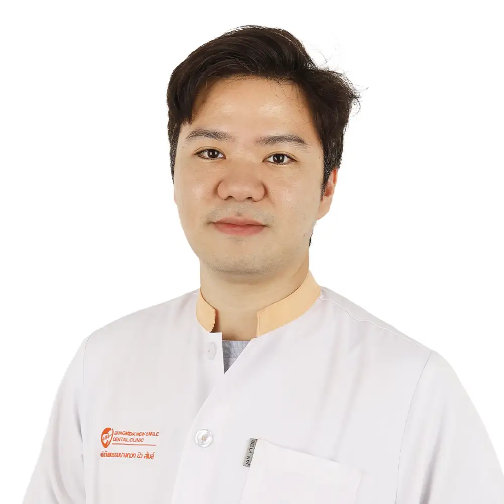 An image of a male dentist in a white gown